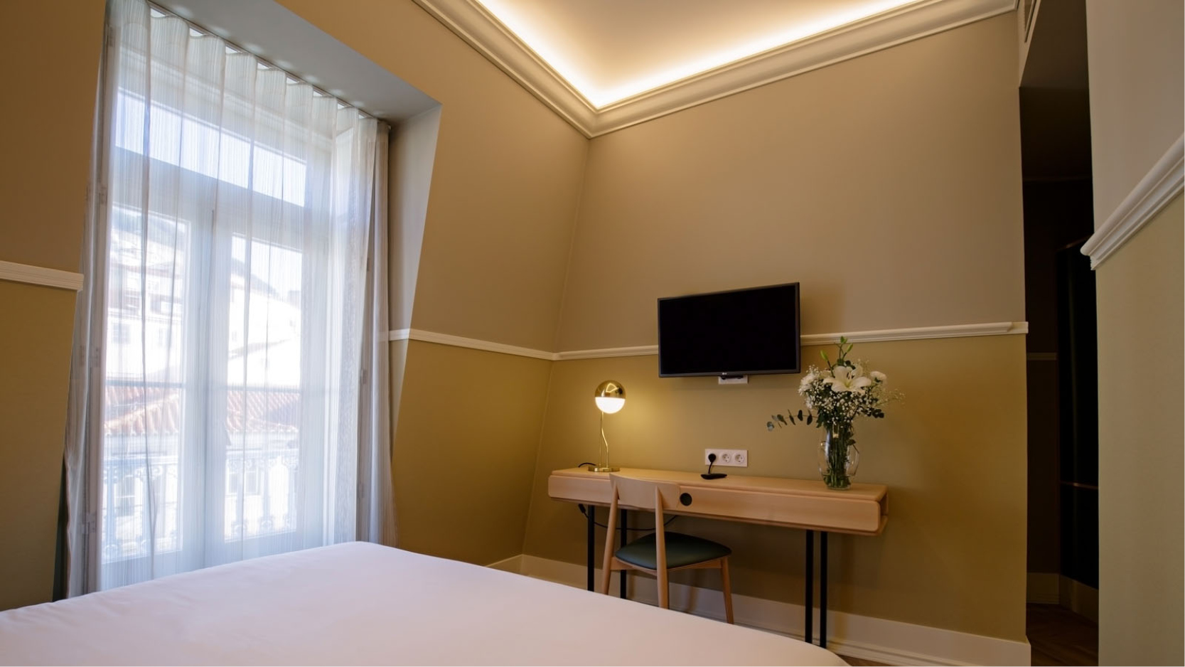 Dubbelrum i beige inredning med stadsutsikt p hotell My Story Hotel Tejo i centrala Lissabon.